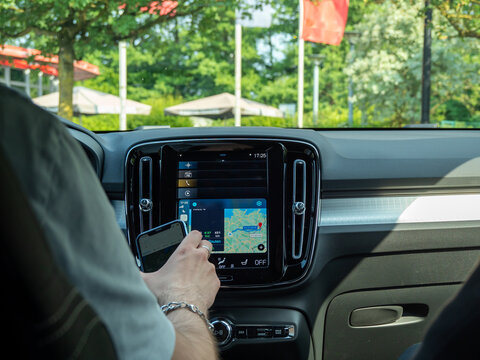 A young man uses a navigator in the car. Modern technology in the car.