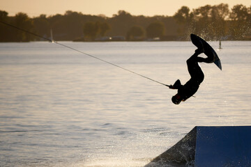 wake boarding on a lake during a golden sunset