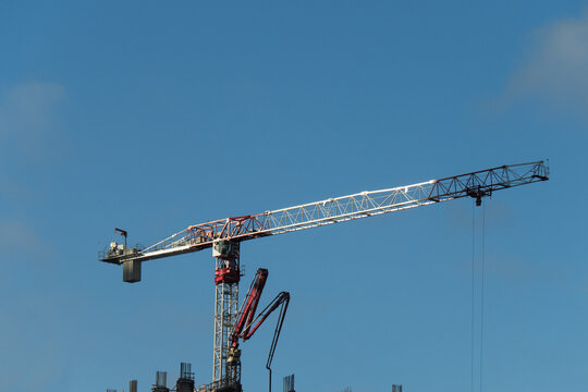A tower crane and a concrete pumper boom on a highrise construction site