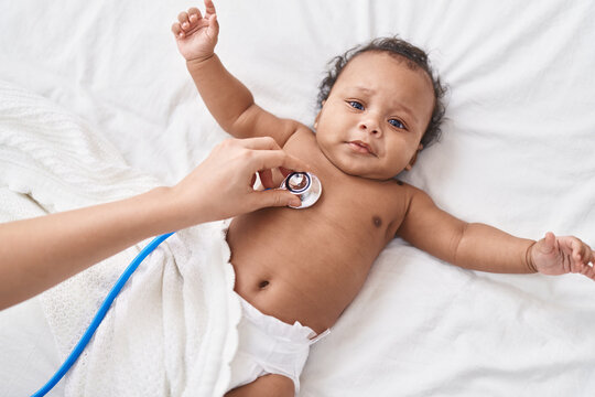 African american baby having medical examination with stethoscope at bedroom
