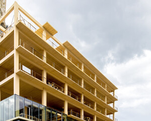 Looking up at the balconies and interior ceiling of a engineered timber multi story, green,...