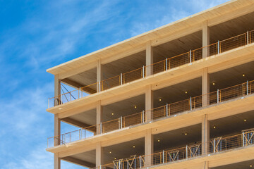 Looking up at the wooden balconys, the vertical supports and interior ceilings of a engineered...