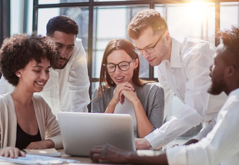 Employees working at computer together, discussing content