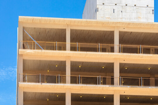 The concrete elevator core  on top of the center of an engineered timber multi story green, sustainable, residential high rise apartment building construction project