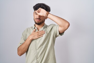 Arab man with beard standing over white background touching forehead for illness and fever, flu and...