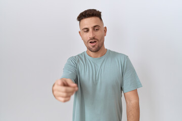 Fototapeta premium Hispanic man with beard standing over white background pointing displeased and frustrated to the camera, angry and furious with you