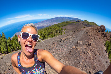Female hiker hiking the Volcanic landscape and hiking trails of the Cumbre vieja route of Volcano craters in south La Palma - Canary Islands