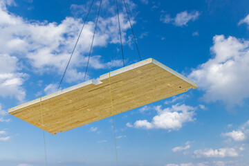 A crane hoisting a pre fabricated laminated floor panel of a mass timber multi story green,...