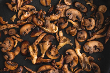 Browned Wild Mushroom s Close-up in a Non-stick Saute Pan Viewed from Above: Overhead view of oyster, shiitake, and crimini mushrooms cooked in butter