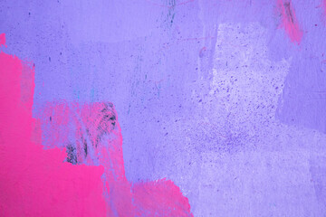 Purple paint strokes and smudges on an pink painted wall background. Abstract wall surface with...