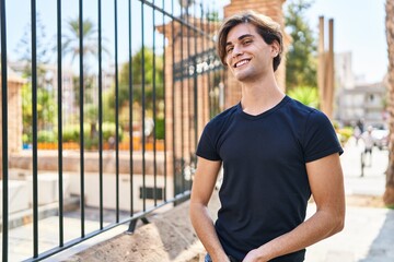 Young caucasian man smiling confident looking to the side at street