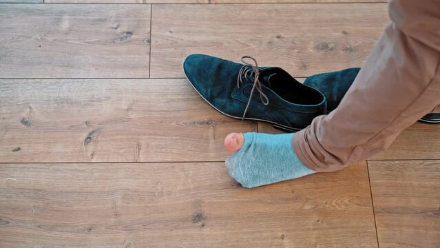 Embarrassed Caucasian Male Taking Off Shoes Discovering Hole in His Sock
