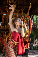 Thailand traditional or cultural dance in Thai costume. The beautiful girl is dancing called Nang Ram, it is noble art of elegance. Thai dancing girl with Siam royal Chariot background