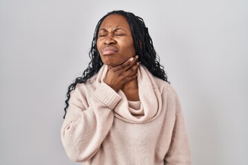African woman standing over white background touching painful neck, sore throat for flu, clod and...