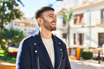 Young hispanic man smiling confident looking to the side at park