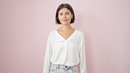 Obraz premium Young beautiful hispanic woman standing with serious expression over isolated pink background