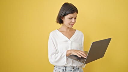 Young beautiful hispanic woman using laptop over isolated yellow background