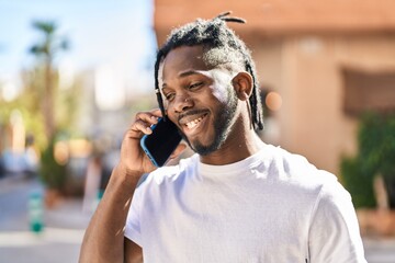 African american woman smiling confident talking on the smartphone at street