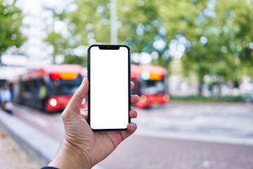 Man holding smartphone showing white blank screen at bus stop