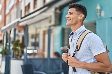 Young hispanic man student smiling confident standing at street