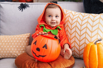 Adorable caucasian baby having halloween party wearing pumpkin costume at home