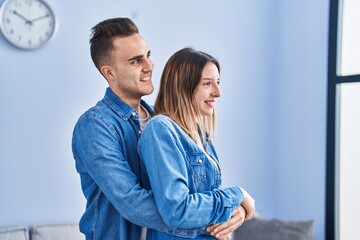 Man and woman couple hugging each other standing at home