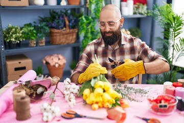 Young bald man florist make bouquet of flowers at flower shop