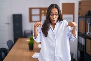 Plakat Young hispanic woman at the office pointing down with fingers showing advertisement, surprised face and open mouth