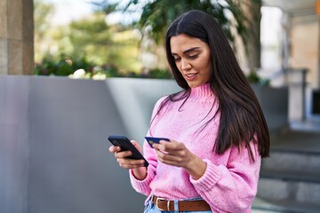 Young hispanic woman smiling confident standing at street