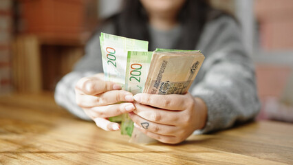Hands of woman counting russian ruble banknotes at room