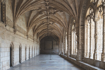 Fototapeta na wymiar Corridor of the cloister in the Jeronimos Monastery with arched stone interior in Lisbon, Portugal