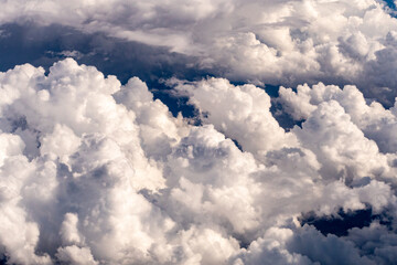 Naklejka na ściany i meble Aerial photograph of clouds outside of my airplane window on a cross country plane trip from Chicago to Los Angeles during the summer