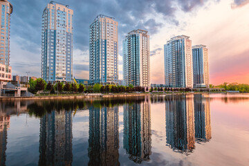 Fototapeta na wymiar Sunset on the embankment in Kyiv. Poznyaki Park near the River Mall.