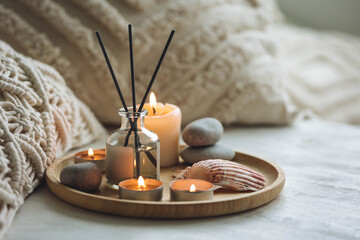 Cozy corner for home meditation and relaxation. Aroma diffuser, burning candles, stones for comfort, pleasure, aromatherapy. Decor for apartment, house, indoors design