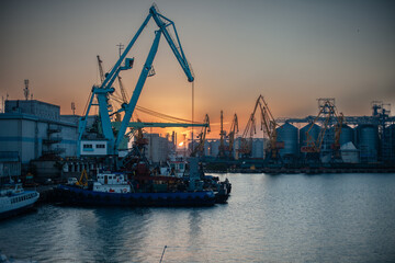 Obraz premium Logistics and transportation of Container Cargo ship and Cargo plane with working crane bridge in shipyard at sunrise, logistic import export and transport industry background, Aerial view from drone