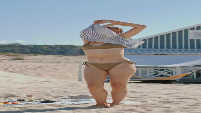Vertical video beach girls taking clothes off. Slim women sunbathing in bikini