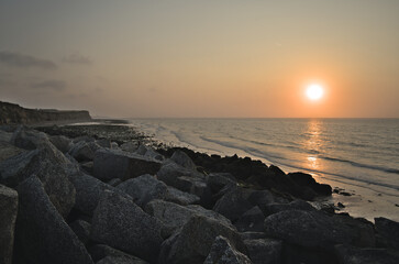 Sunset over the sea with sea rocks in foreground