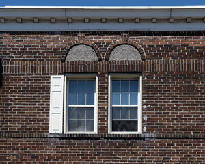 Two windows in an old brick wall