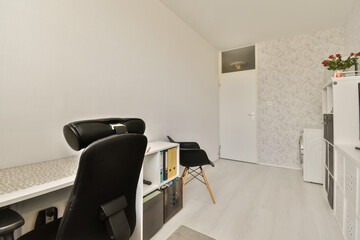 a room with a desk, chair and television set in the corner on the left side of the room is a white wallpaper