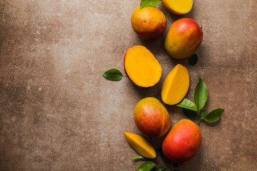 Fototapeta na wymiar Mango background design concept. Top view of fresh mango fruit pattern with leaves on table.