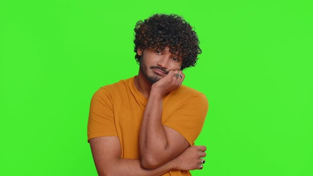 Tired bored young indian man indifferent expression, exhausted of tedious story, not interested in communication talk, displeasure, uninteresting. Hindu guy isolated on green chroma key background