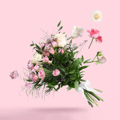 Fototapeta na wymiar Rose buds flying into bunch of flowers on pink background. Beautiful bouquet