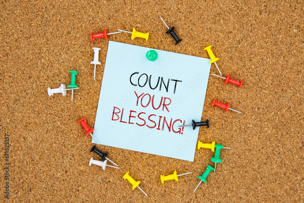 Poster count your blessing text on light blue post-it paper pinned on bulletin cork board surrounding by mu