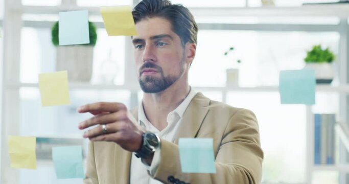 Business man, glass wall and planning for ideas, sticky note and writing with brainstorming, goal and board. Businessman, moodboard and strategy in office for problem solving, solution and notes