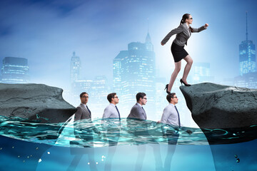 Inequal competition concept with businesswoman walking on heads