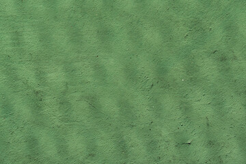 View of a green and red tennis court with nature all around. Widely used for sports and playing tennis