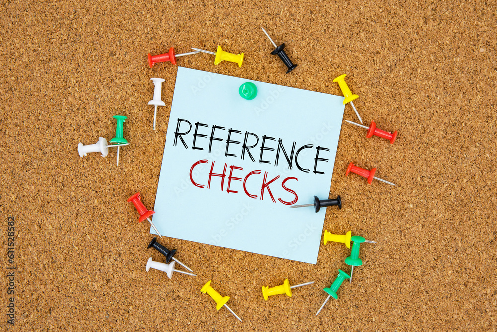 Poster reference checks text on light blue post-it paper pinned on bulletin cork board surrounding by multi