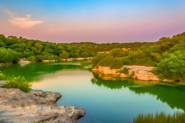uma bela paisagem natural durante o pôr do sol, um lago tranquilo com águas cristalinas que refletem as cores do céu