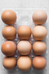 Top view of a crate of eggs on a marble surface, Eggs in a transparent plastic crate, organic eggs on a table