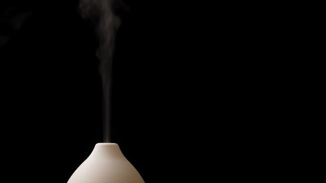 Diffuser with white light diffusing steam on black background. Closeup